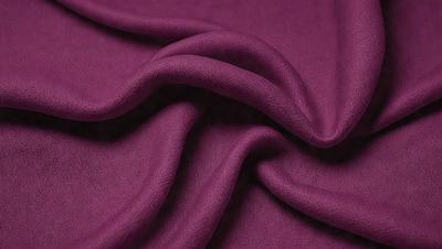 The primary subject of the image is a purple fabric, which is the main object, scene, or focus of the image. The setting or background is a purple sheet, and the visual style is a photo. The colors and mood of the image are predominantly purple, creating a calm and soothing atmosphere.