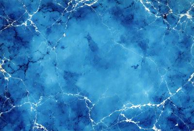 The primary subject of the image is a blue marble wall with a pattern of white and blue swirls. The setting is a room with a blue marble floor, and the visual style is a close-up of the marble wall. The colors and mood of the image are predominantly blue, creating a serene and calming atmosphere.