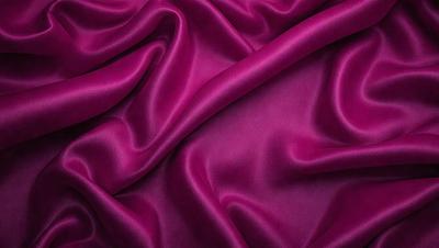 The primary subject of the image is a purple fabric, which is the main object, scene, or focus of the image. The setting or background is a purple fabric, and the visual style is a photo. The dominant colors and overall atmosphere are purple, creating a rich and luxurious appearance.