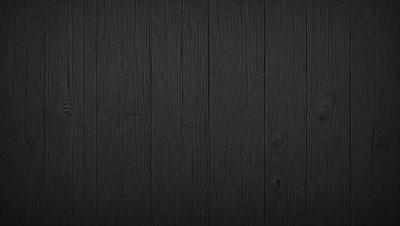 The primary subject of the image is a wooden floor. The setting is a dark room, and the visual style is a black and white photo. The colors and mood of the image are predominantly dark, creating a moody atmosphere.