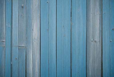 The primary subject of the image is a blue wooden wall. The setting is a room with a blue wooden wall, and the visual style is a photo. The dominant colors are blue and white, creating a calm and serene atmosphere.