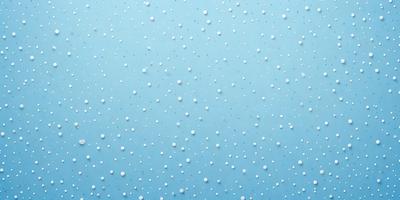 The primary subject of the image is a blue wall with white dots on it. The setting is a room with a blue background. The visual style is a close-up of the wall, showcasing the white dots. The colors and mood of the image are predominantly blue and white, creating a calm and serene atmosphere.