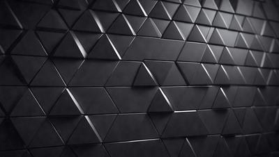 The primary subject of the image is a black and white patterned wall. The setting is a dark room with a black background. The visual style is a close-up of the wall, showcasing the intricate pattern. The colors and mood are predominantly black and white, creating a sense of depth and contrast.