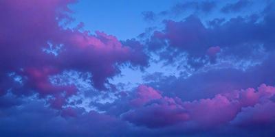 The primary subject of the image is a cloudy sky with purple hues. The setting is a nighttime scene, with the sky serving as the backdrop. The visual style is a natural, outdoor scene, and the colors and mood convey a sense of tranquility and beauty.