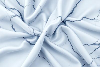 The primary subject of the image is a white sheet of fabric with a blue pattern. The setting is a white background, and the visual style is a close-up of the fabric. The colors and mood of the image are predominantly white and blue, creating a calm and serene atmosphere.