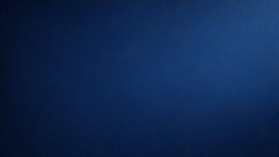 The primary subject of the image is the sky, which is a deep blue color. The setting is a vast, open space with no visible landmarks or objects. The visual style is a natural, outdoor scene. The colors and mood convey a sense of tranquility and calmness.