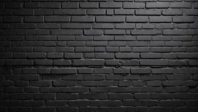 The primary subject of the image is a black brick wall. The setting is a brick wall, and the visual style is a photo. The dominant colors are black and grey, creating a moody atmosphere.