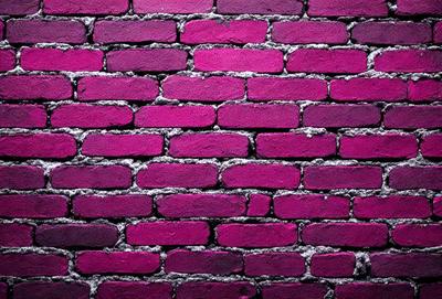 The primary subject of the image is a brick wall painted in a pinkish hue. The setting is a brick wall, and the visual style appears to be a photo. The dominant colors in the image are pink and purple, creating a warm and inviting atmosphere.