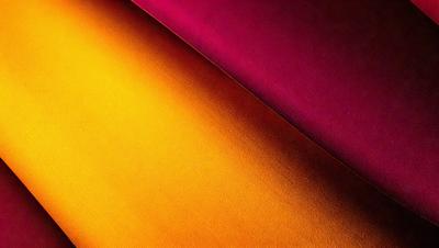 The primary subject of the image is a piece of fabric, which is the main object in the scene. The setting is a table, and the visual style is a photo. The colors in the image are predominantly orange and purple, creating a warm and vibrant atmosphere.