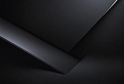 The primary subject of the image is a black square, which is the main object, scene, or focus of the image. The setting or background is a black surface, which creates a contrast with the black square. The visual style of the image is a close-up of the black square, showcasing its details. The colors and mood of the image are predominantly black, giving it a bold and striking appearance.