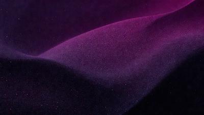 The primary subject of the image is a purple surface, which appears to be a piece of fabric or a curtain. The setting is a dark room, and the visual style is a close-up of the purple surface. The colors and mood of the image are predominantly purple, creating a calm and serene atmosphere.