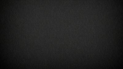 The primary subject of the image is a black background. The setting is a dark room, and the visual style is a black and white photo. The colors and mood of the image are dark and moody, creating a sense of mystery or drama.