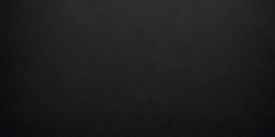 The primary subject of the image is a black background. The setting is a dark room, and the visual style is a black and white photo. The colors and mood of the image are dark and moody, creating a sense of mystery or drama.