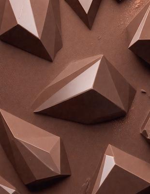 The image features a close-up of a chocolate cake with a pattern of triangles on it. The cake is placed on a brown surface, which could be a table or a counter. The triangles on the cake are arranged in a way that creates a visually appealing design. The overall atmosphere of the image is warm and inviting, as the chocolate cake is a popular dessert choice.