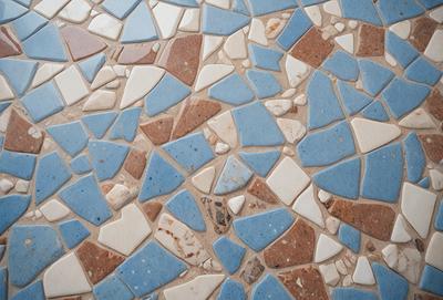 The primary subject of the image is a blue and white tile mosaic. The setting is a wall with a blue and white tile pattern. The visual style is a close-up of the tile mosaic, showcasing the intricate design. The colors and mood of the image are predominantly blue and white, creating a clean and elegant atmosphere.