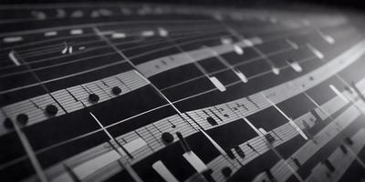 The primary subject of the image is a musical score, which is displayed on a black background. The setting appears to be a sheet of music, possibly a piano sheet, with the notes and symbols clearly visible. The visual style of the image is a combination of a photo and a drawing, creating a unique and artistic representation of the musical score. The colors and mood of the image are predominantly black, which adds a sense of depth and sophistication to the composition.