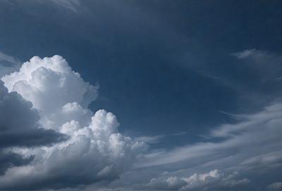 The primary subject of the image is a cloudy sky with a few clouds scattered throughout. The setting is a blue sky, which serves as the backdrop for the clouds. The visual style of the image is a photo, capturing the natural beauty of the cloudy sky. The colors in the image are predominantly shades of blue and white, creating a calm and serene atmosphere.