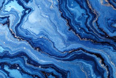 The primary subject of the image is a blue and gold swirling pattern, which appears to be a piece of art or a decorative surface. The setting is a dark background, which contrasts with the vibrant colors of the swirling pattern. The visual style is a close-up of the pattern, showcasing its intricate details. The dominant colors are blue and gold, creating a sense of depth and richness in the artwork.