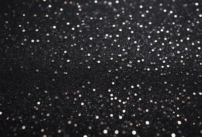 The primary subject of the image is a black background with a pattern of white dots. The setting is a dark room, and the visual style is a close-up of the dots. The colors are predominantly black and white, creating a mood of simplicity and elegance.