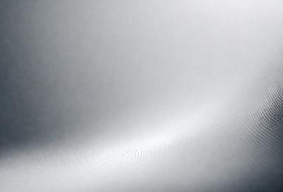 The primary subject of the image is a white sheet of fabric. The setting is a white background, which creates a clean and minimalist appearance. The visual style is a close-up of the fabric, showcasing its texture and details. The colors and mood of the image are predominantly white, giving it a calm and serene atmosphere.