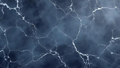 The primary subject of the image is a close-up of a marble wall with a blue background. The setting is a dark room, and the visual style is a photo. The dominant colors are blue and gray, creating a moody atmosphere.
