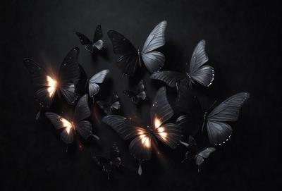 The primary subject of the image is a group of black butterflies. They are arranged in various positions, with some butterflies flying close to each other and others flying further apart. The setting is a dark background, which creates a dramatic and moody atmosphere. The visual style of the image is a combination of photo and digital art, as it captures the beauty of the butterflies in a visually appealing manner. The colors and mood of the image are predominantly dark, with the black but