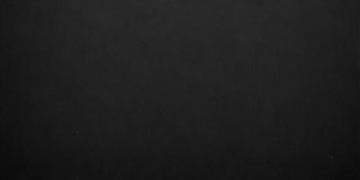 The primary subject of the image is a black background. The setting is a dark room, and the visual style is a black and white photo. The colors and mood of the image are dark and moody, creating a sense of mystery or drama.
