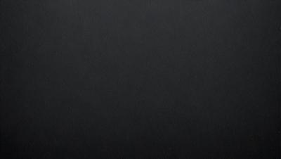 The primary subject of the image is a black background. The setting is a dark room, and the visual style is a black and white photo. The colors and mood of the image are predominantly dark and moody.