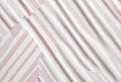 The primary subject of the image is a striped paper, which is displayed in a pink and white color scheme. The setting is a white background, and the visual style appears to be a photo. The dominant colors and overall atmosphere of the image are pink and white, creating a clean and elegant appearance.
