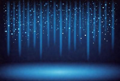 The primary subject of the image is a blue background with a pattern of white dots. The setting is a dark room, and the visual style appears to be a digital art or illustration. The dominant colors are blue and white, creating a calm and serene atmosphere.