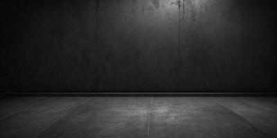The primary subject of the image is a black wall with a grey floor. The setting is a room with a black wall and a grey floor. The visual style is a black and white photo. The colors and mood of the image are dark and moody, creating a sense of emptiness and solitude.