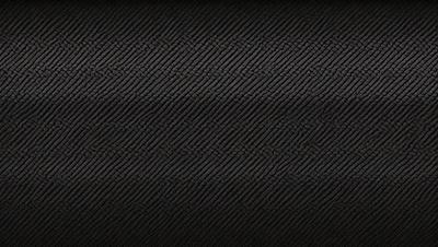 The primary subject of the image is a black and white patterned fabric. The setting is a black background, which contrasts with the patterned fabric. The visual style is a close-up of the fabric, showcasing its intricate design. The colors and mood of the image are predominantly black and white, giving it a classic and timeless appearance.