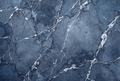 The primary subject of the image is a blue marble wall with a pattern of white and black swirls. The setting is a room with a blue marble wall, and the visual style is a close-up of the wall. The colors and mood of the image are predominantly blue and black, creating a calm and sophisticated atmosphere.