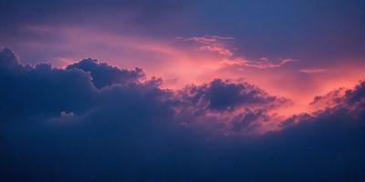 The primary subject of the image is a beautiful sunset with a pink sky. The setting is a cloudy sky, and the visual style is a photo. The colors and mood of the image are warm and serene, creating a peaceful atmosphere.