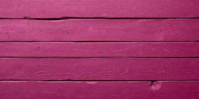 The primary subject of the image is a wooden wall with a pinkish hue. The setting is a room with a wooden surface, and the visual style appears to be a photo. The dominant colors in the image are pink and brown, creating a warm and inviting atmosphere.