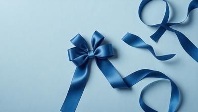 The primary subject of the image is a blue bow, which is prominently displayed on a blue background. The visual style of the image is a close-up of the bow, showcasing its details and texture. The colors and mood of the image are predominantly blue, creating a calm and serene atmosphere.