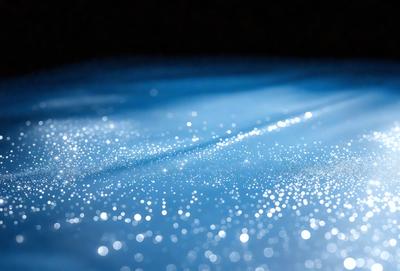 The primary subject of the image is a blue surface with a pattern of sparkling lights. The setting appears to be a dark room, and the visual style is a combination of a photo and digital art. The dominant colors are blue and white, creating a serene and calming atmosphere.