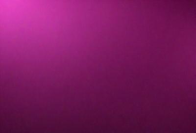 The primary subject of the image is a large, pink wall. The setting is a room with a purple background. The visual style is a close-up of the wall, which gives a sense of depth and texture. The dominant colors are pink and purple, creating a warm and inviting atmosphere.