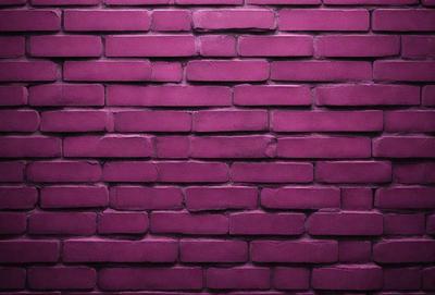 The primary subject of the image is a brick wall painted in a purple hue. The setting is a brick wall, and the visual style is a photo. The dominant colors are purple and pink, creating a warm and inviting atmosphere.