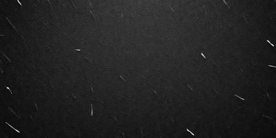 The primary subject of the image is a black leather surface. The setting is a dark room, and the visual style is a close-up of the leather surface. The colors and mood of the image are predominantly dark and moody, with the black leather providing a striking contrast against the dark background.