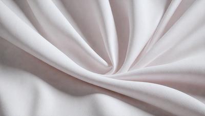 The primary subject of the image is a white sheet of fabric, which is the main object, scene, or focus of the image. The setting is a white background, which provides a clean and minimalistic environment. The visual style is a close-up of the fabric, showcasing its texture and details. The colors and mood of the image are predominantly white, giving it a clean and serene atmosphere.