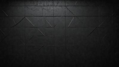 The primary subject of the image is a black wall with a pattern of triangles. The setting is a dark room, and the visual style appears to be a pattern or texture. The dominant colors are black and grey, creating a moody atmosphere.