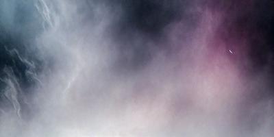 The primary subject of the image is a cloudy sky. The setting is a cloudy day, and the visual style is a photo. The colors and mood of the image are predominantly dark and moody, with the clouds creating a dramatic atmosphere.