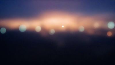 The primary subject of the image is a night sky filled with a multitude of stars. The setting is a dark, cloudy night, with the stars scattered across the sky. The visual style is a photo, capturing the beauty of the night sky. The colors and mood of the image are predominantly dark and moody, with the stars providing a contrasting and serene atmosphere.