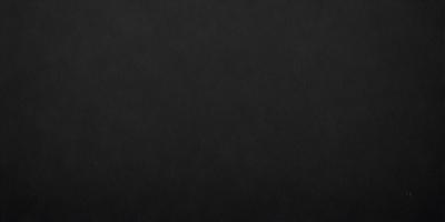 The primary subject of the image is a black leather surface. The setting is a dark room, and the visual style is a close-up of the leather surface. The colors and mood of the image are predominantly dark and moody, with the black leather serving as the focal point.