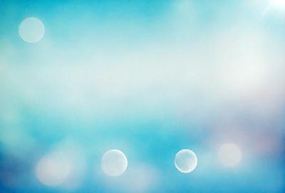 The primary subject of the image is a blue sky with three white orbs floating in it. The setting is a clear, cloudless day, and the visual style appears to be a photo or a digital artwork. The colors and mood of the image are predominantly blue and serene, creating a peaceful and tranquil atmosphere.