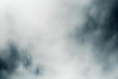 The primary subject of the image is a cloudy sky. The setting is a cloudy day with a gray and white sky. The visual style is a photo, capturing the natural beauty of the cloudy sky. The colors and mood of the image are predominantly gray and white, creating a calm and serene atmosphere.