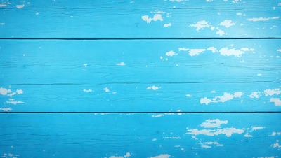 The primary subject of the image is a blue wooden wall with a cloudy pattern. The setting is a room with a blue wooden floor. The visual style is a combination of a photo and digital art, creating a unique and artistic atmosphere. The dominant colors are blue and white, with the blue wooden wall and floor, and the white clouds on the wooden surface.