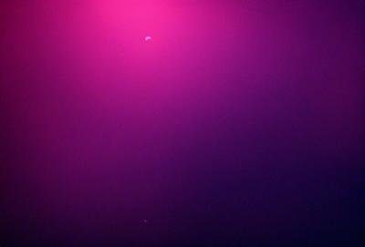 The primary subject of the image is a pink background with a purple hue. The setting is a dark room, and the visual style appears to be a digital art or illustration. The dominant colors and overall atmosphere are a mix of pink and purple, creating a warm and inviting ambiance.
