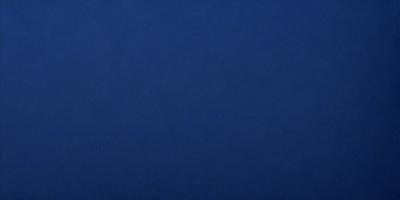 The primary subject of the image is a large, dark blue surface. The setting is a vast, empty space with no visible objects or backdrop. The visual style is a simple, monochromatic design. The dominant colors are dark blue and black, creating a calm and serene atmosphere.
